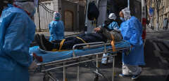 Medical staff in protective clothes are seen carrying a patient from an apartment suspected of having the virus in Wuhan, in Hubei province on January 30, 2020. - The World Health Organization, which initially downplayed the severity of a disease that has now killed 170 nationwide, warned all governments to be "on alert" as it weighed whether to declare a global health emergency. (Photo by Hector RETAMAL / AFP)