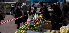 This picture taken on March 25, 2020 shows a placard reading " we serve you" near fresh fruits at a local street market in Givors, near Lyon, on the day nine of a strict lockdown in France to stop the spread of COVID-19 (novel coronavirus). (Photo by JEAN-PHILIPPE KSIAZEK / AFP)