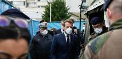 French President Emmanuel Macron (C) wears a face mask during the visit of the military field hospital outside the Emile Muller Hospital in Mulhouse, eastern France, on March 25, 2020, on the ninth day of a lockdown aimed at curbing the spread of the COVID-19 (novel coronavirus) in France. (Photo by Mathieu CUGNOT / POOL / AFP)