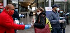 Volunteers distribute face masks and leaflets to commuters in front of the Gare du Nord train station in Paris on April 29, 2020, on the 44th day of a lockdown in France aimed at curbing the spread of the COVID-19 disease, caused by the novel coronavirus. - French Prime Minister announced on April 28 that face masks will be compulsory on public transport as France will begin a gradual but "risky" return to normality on May 11. (Photo by THOMAS COEX / AFP)