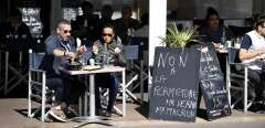 TOPSHOT - Two person have lunch at the terrace of a restaurant next to a sign reading " No to the closing "  in Marseille, southern France, on September 28, 2020. - The Marseille administrative court will examine on September 29 the appeal by President of the Provence-Alpes-Cote-d'Azur region Renaud Muselier against the prefectural decree ordering the total closure for two weeks of bars and restaurants in Aix-en- Provence and Marseille. (Photo by NICOLAS TUCAT / AFP)