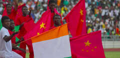 A group of performers hold Chinese and Ivorian flags during the inauguration ceremony of Ivory Coast's new 60,000-seat Olympic stadium, built with the help of China, in Ebimpe, outside Abidjan, on October 3, 2020 ahead of 2023 Africa Cup of Nations. (Photo by Issouf SANOGO / AFP)