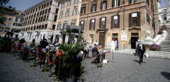 People have lunch on the terraces set-up outside a restaurant in Rome's central Spanish Steps square on April 26, 2021. - Bars, restaurants, cinemas and concert halls will partially reopen across Italy on April 26 in a boost for coronavirus-hit businesses, as parliament debates the government's 220-billion-euro ($266-billion) EU-funded recovery plan. After months of stop-start restrictions imposed to manage its second and third waves of Covid-19, Italy hopes this latest easing will mark the start of something like a normal summer. (Photo by Filippo MONTEFORTE / AFP)