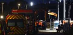 Firefighters and rescuers gather at the Massy-Palaiseau train station on the outskirts of Paris, at night, on July 25 2021, after a construction worker died following a landslide earlier in the day. - The rail company SNCF interrupted its services between the Montparnasse train station and southwestern France. (Photo by Sameer Al-DOUMY / AFP)