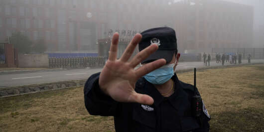 FILE - In this Feb. 3, 2021, file photo, a security person moves journalists away from the Wuhan Institute of Virology after a World Health Organization team arrived for a field visit in Wuhan in China's Hubei province. A member of the expert team investigating the origins of the coronavirus in Wuhan says the Chinese side granted full access to all sites and personnel they requested to visit and meet with. (AP Photo/Ng Han Guan, File)/XHG305/21036594536770//2102051846