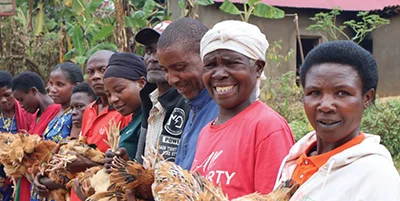 People lined up holding GFA World provided chickens