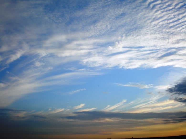 Wispy clouds streak across a blue sky.