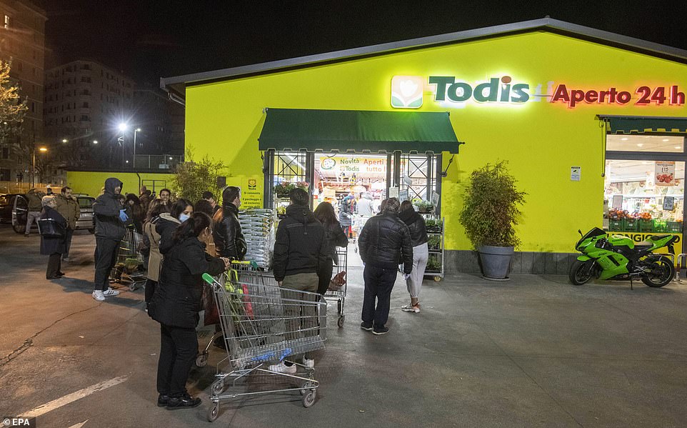 People queue for groceries at a supermarket in Rome last night, with the unprecedented quarantine due to last until April 3