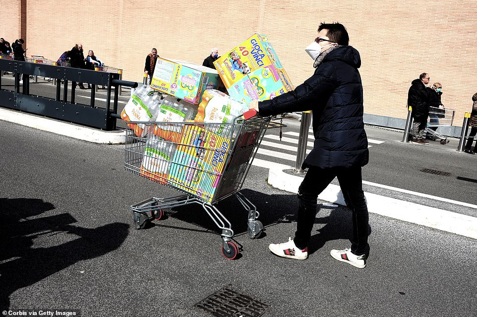 A man pushes an overflowing shopping trolley near a shop in Rome today despite one doctor's warning against stocking up