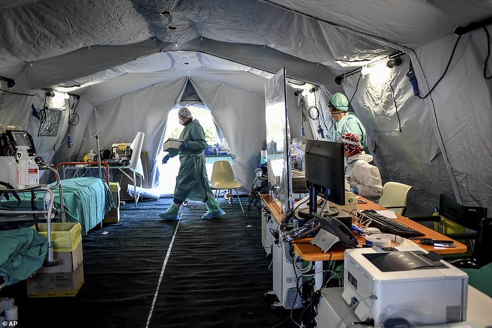 Medical personnel working inside one of the emergency structures that were set up to ease procedures outside the hospital of Brescia on Monday