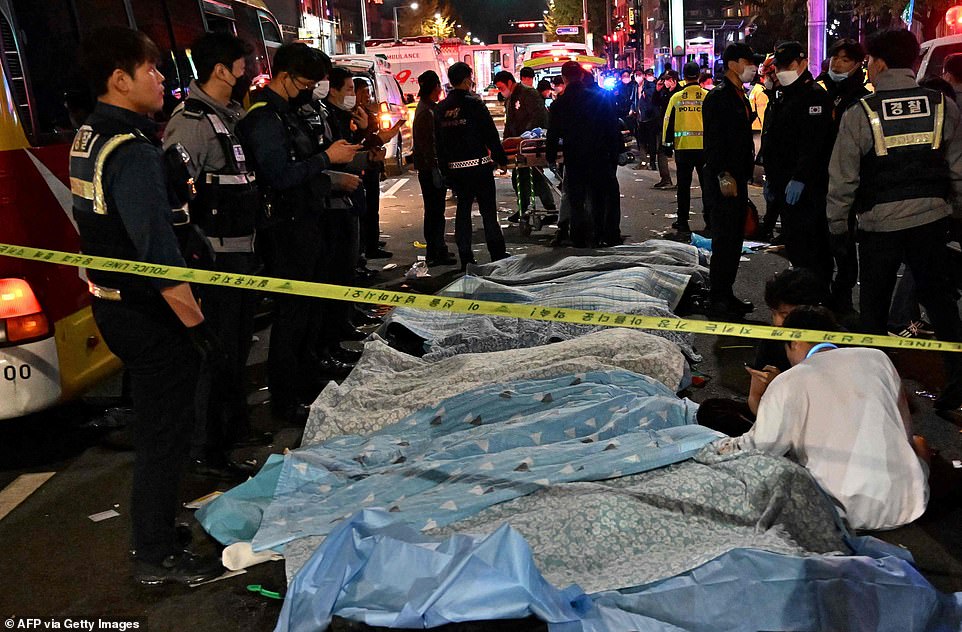 The bodies of victims, believed to have suffered from cardiac arrest, are covered with sheets in the popular nightlife district of Itaewon in Seoul