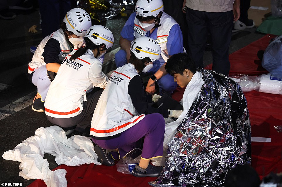Emergency workers treat some of those injured in the crush, covering them with foil blankets to keep them warm