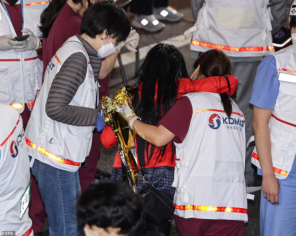 A woman caught up in the horrifying incident is helped by emergency workers, who appear to be taking her to receive medical treatment