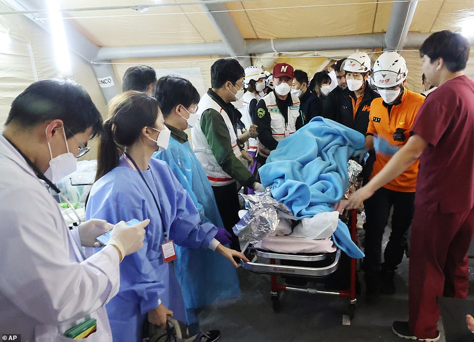 Rescue workers carry an injured person to the hospital in Seoul. Temporary tents have been set up by emergency services around the capital to treat those wounded in the crowd