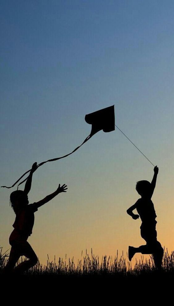 Two kids having some kiting fun in the evening air. An elegant visual expression of the joy of flying kites!