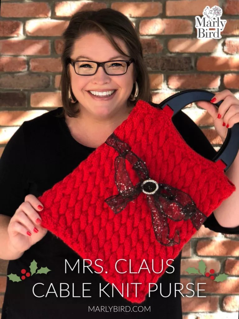 Mrs. Claus Purse with knitted cables by Marly Bird. Includes wooden purse handles for the purse. 