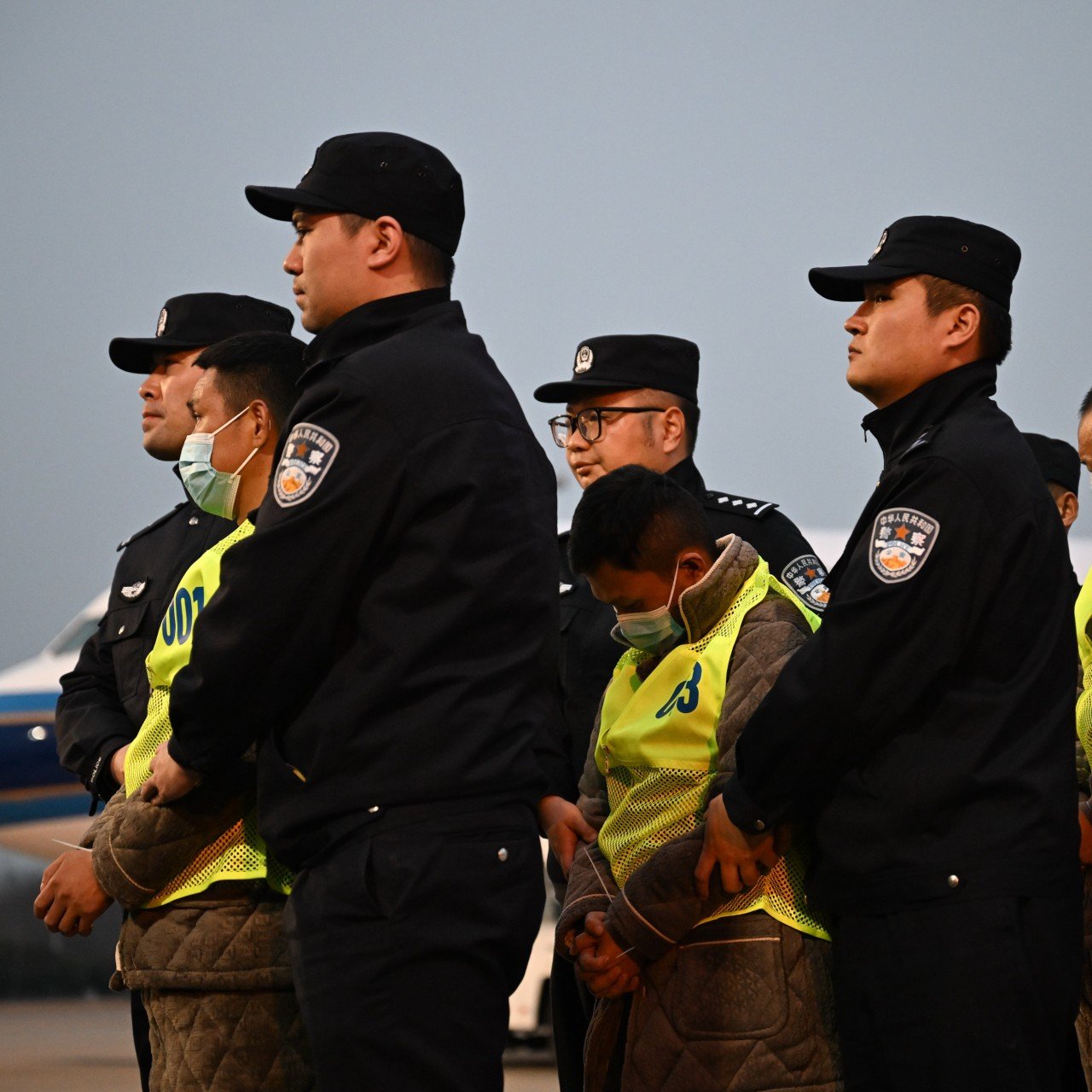 A polícia chinesa escolta cidadãos chineses suspeitos de envolvimento em fraudes de telecomunicações após serem repatriados de Mianmar, em Nanquim, em 20 de fevereiro. Foto: Xinhua