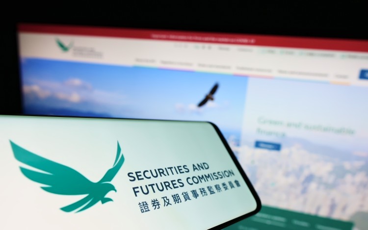 Um celular mostrando o logotipo da Comissão de Valores Mobiliários e Futuros de Hong Kong. Foto: Shutterstock