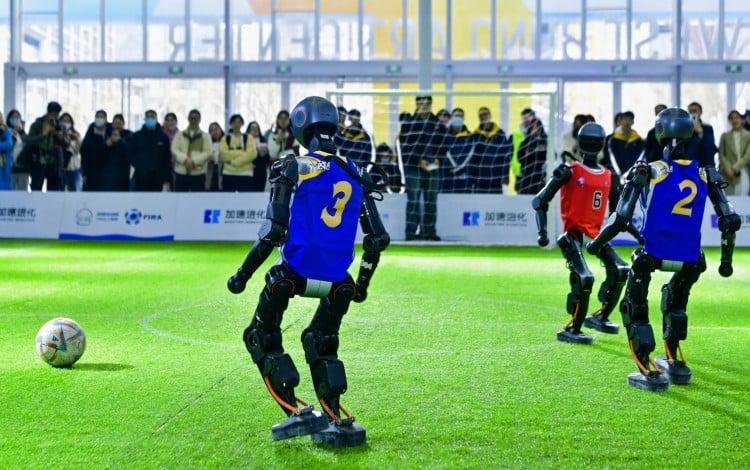 Robôs humanoides jogam futebol na Global Developer Conference, um evento de IA realizado em Xangai. Foto: Folheto