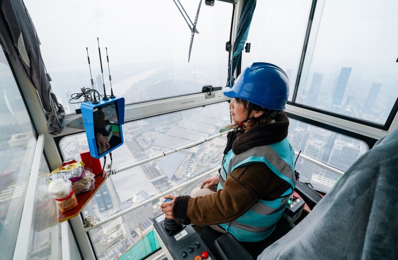Um operador de guindaste está sentado no alto do canteiro de obras da Cidade Financeira de Nanquim, na província de Jiangsu, em 6 de março de 2024. Foto: Xinhua