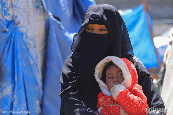 In Yemen, a displaced mother holds her young daughter.