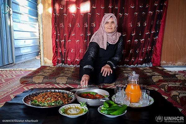 Layla, a Syrian refugee in Zaatari camp, displaying the ingredients needed to make ‘Meat in a Tray’ and Fattoush