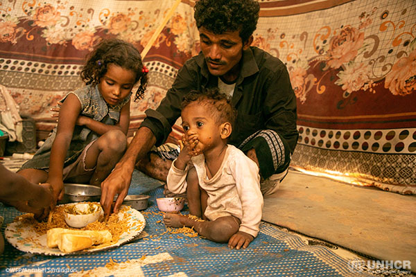Family has a meal in an IDP camp in Aden