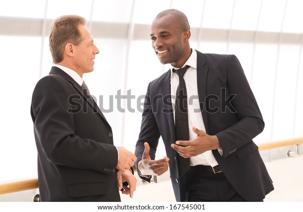 Business communication. Two cheerful business men talking to each other and gesturing