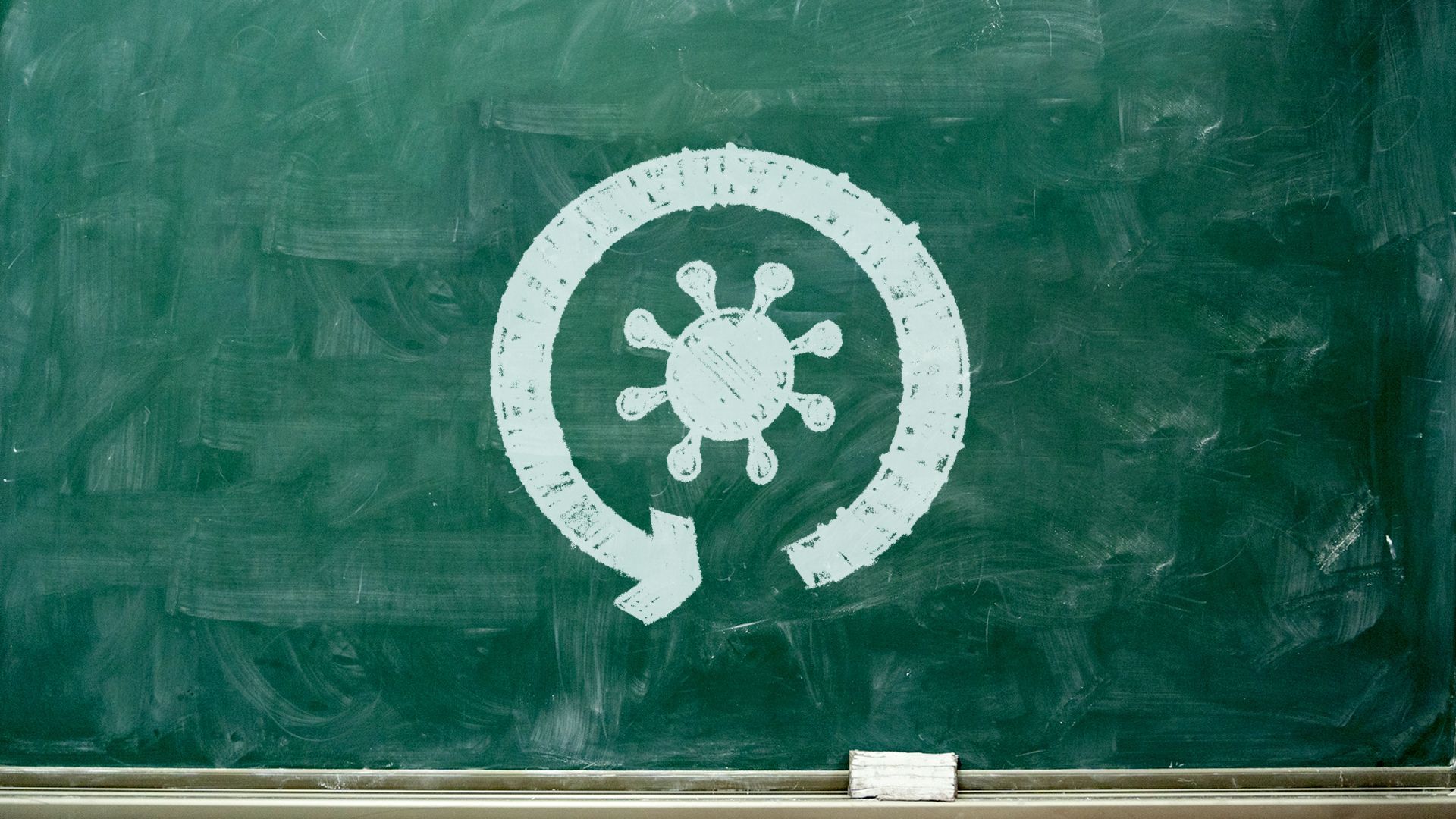 Illustration of a chalkboard with a circular arrow and a coronavirus icon drawn in chalk.