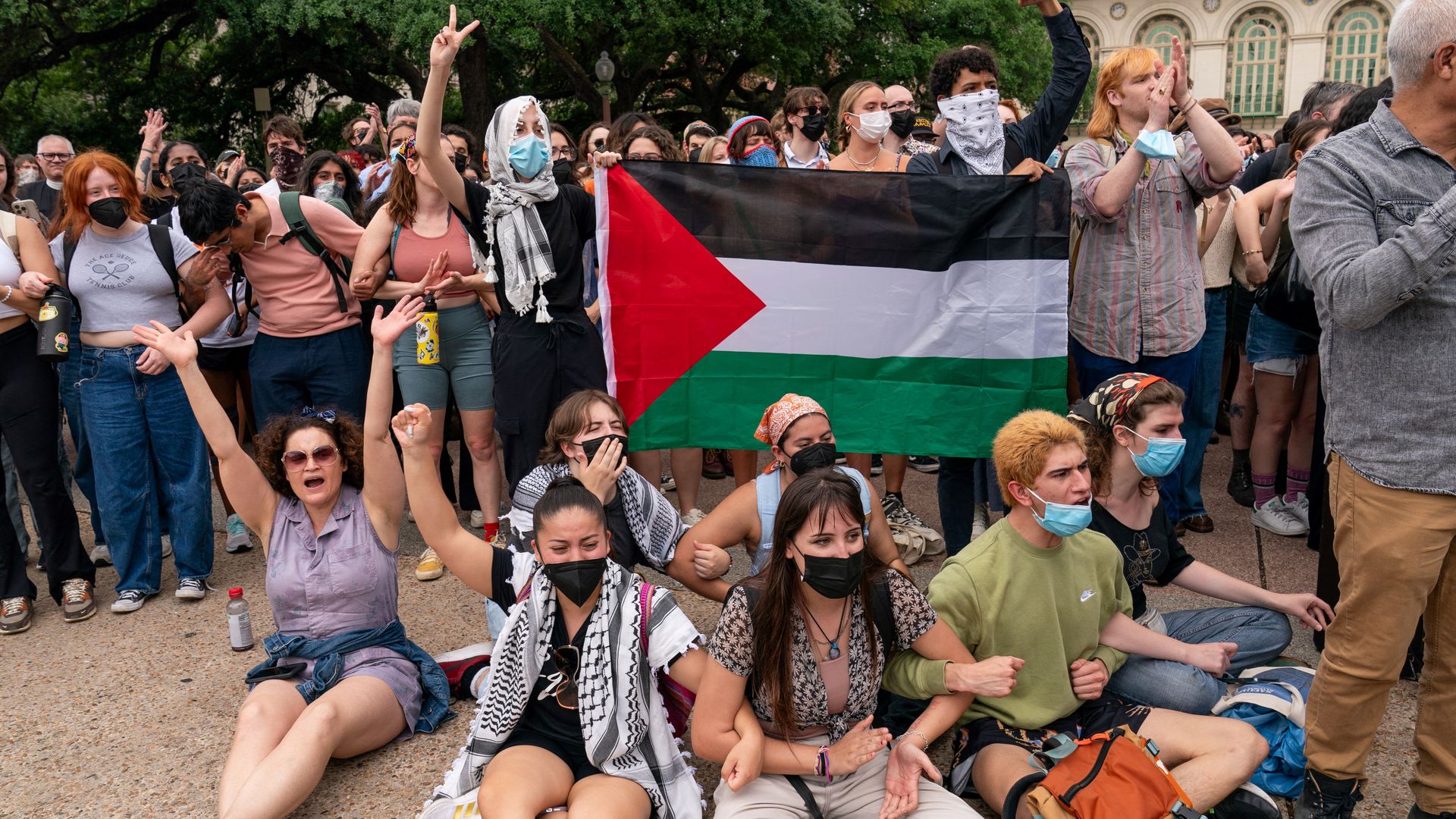 A photo of students holding up a Palestinian flag during a protest
