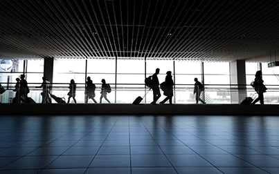 Imagem mostra pessoas caminhando com malas em um aeroporto