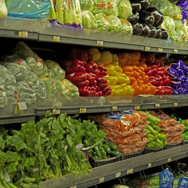 grocery shelf of plastic wrapped vegetables