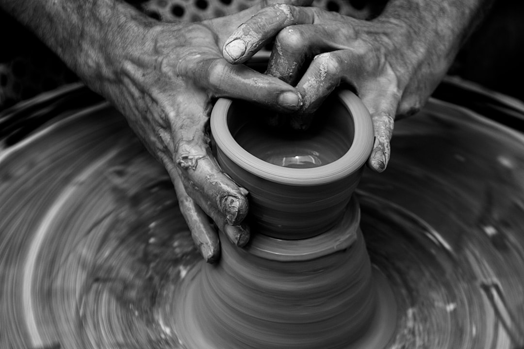 Messy hands sculpting on a pottery wheel in motion Photo by Quino Al on Unsplash
