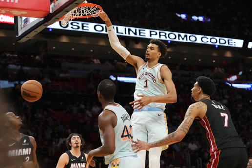 O pivô do San Antonio Spurs, Victor Wembanyama (1), enterra a bola sobre o pivô do Miami Heat, Kel'el Ware (7), durante o segundo tempo de uma partida de basquete da NBA, domingo, 19 de janeiro de 2025, em Miami. (Foto AP/Lynne Sladky)