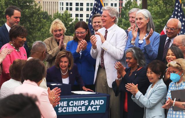 CHIPS-v1_Signing.jpg Members of Congress, including Assistant Speaker Katherine Clark, stand around and clap while Speaker Pelosi signs the CHIPS and Science Act, sending it to President Biden for his signature.