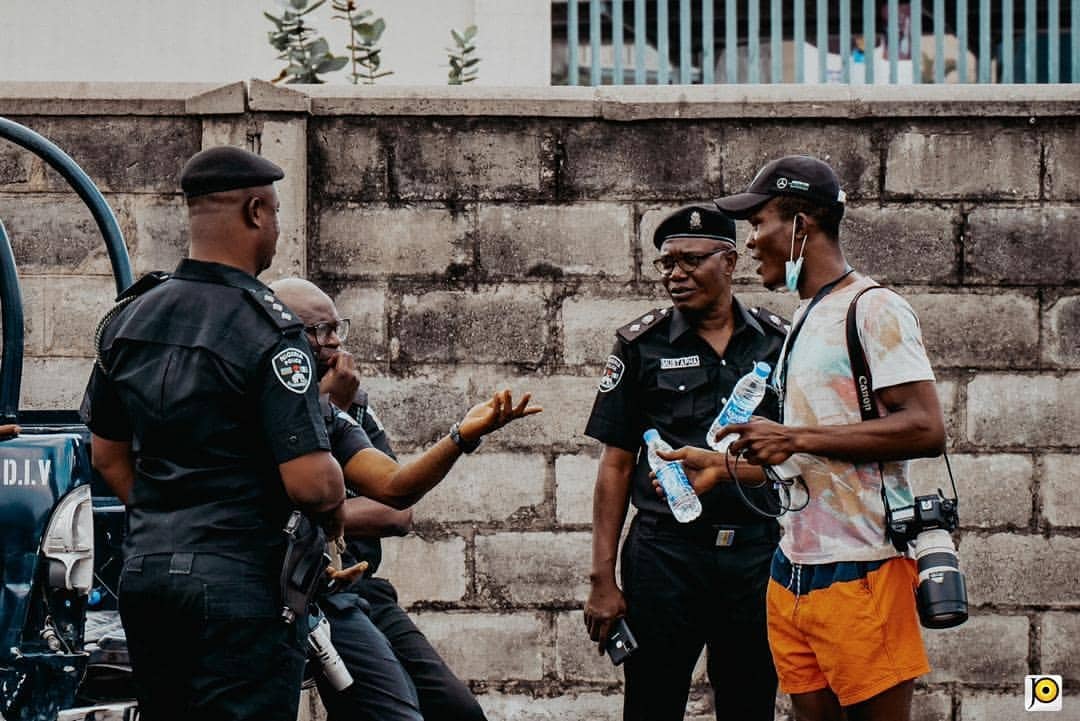 Akpan having a chat with police officers in Lagos during the protests, Oct. 13, 2020. Photo: JOPStudios