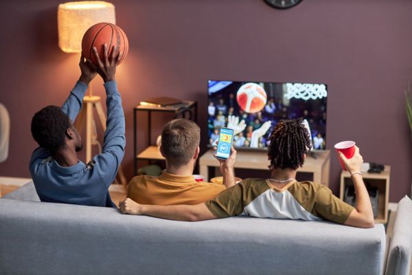 Three young guys watching basketball. 