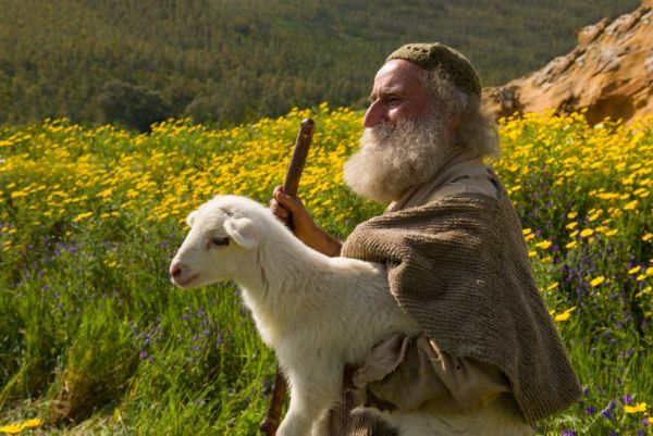A shepherd carrying a lamb