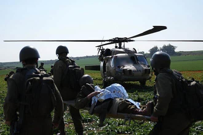 IDF medical corps troops evacuate a wounded colleague to a waiting helicopter. (Credit: Israel Defense Forces) IDF medical corps troops evacuate a wounded colleague to a waiting helicopter. (Credit: Israel Defense Forces)
