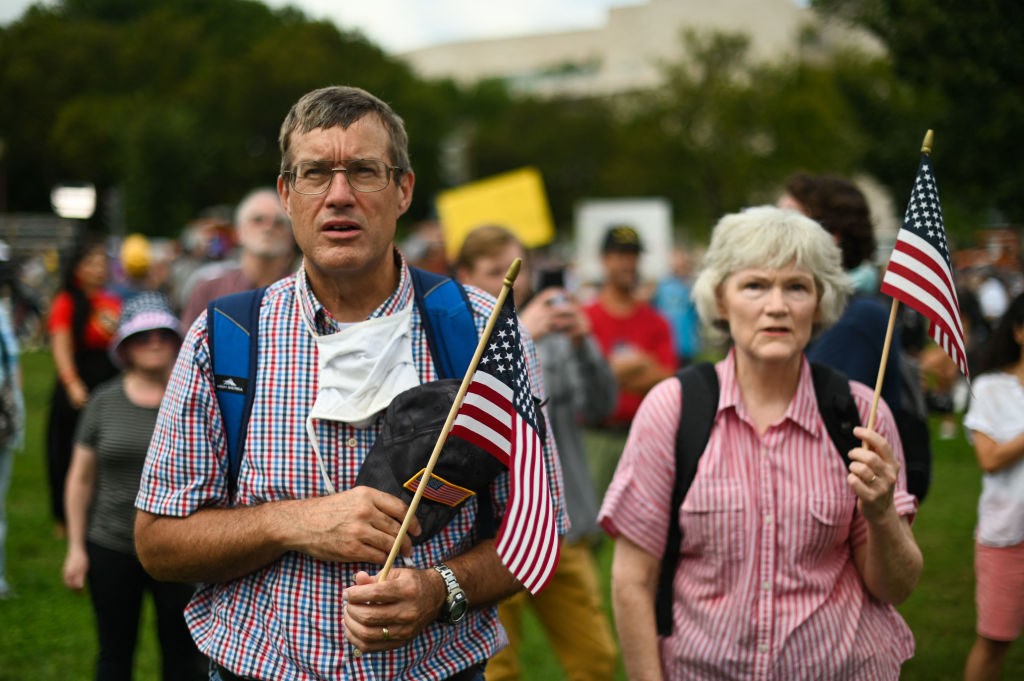 A couple recites the US Pledge of Allegiance as demonstrators gather for the Justice for J6 rally in Washington, DC, on September 18, 2021, in support of the pro-Trump rioters who ransacked the US Capitol on January 6, 2021. - Washington was on high alert for the rally with security forces better prepared to avoid a repeat of the January 6 attack on the Capitol. US Capitol police said they have no indication of a specific plot associated with the rally, but warned in a news conference there had been some threats of violence, with a counter-rally scheduled to take place nearby. (Photo by ROBERTO SCHMIDT / AFP) (Photo by ROBERTO SCHMIDT/AFP via Getty Images)
