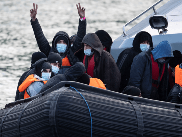 Migrants react onboard UK Border Force vessel HMC Speedwell after being picked up at sea, as they are brought into the Marina in Dover, southeast England, on December 21, 2021. - Migrants who crossed the Channel to Britain from northern France are being held in sub-standard conditions, despite government promises …