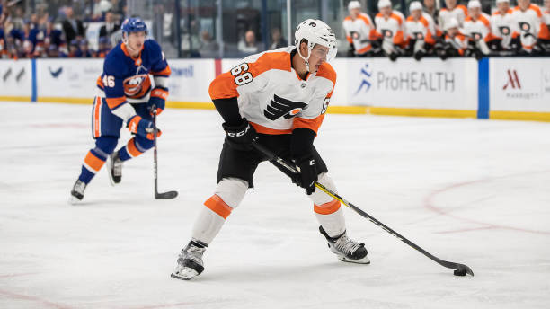 Philadelphia Flyers center Morgan Frost brings the puck in the offensive zone after beating New York Islanders defenseman Bode Wilde in a pre-season...