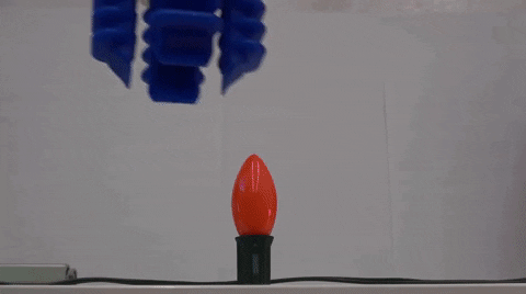 A robot hand turning on a lightbulb 
