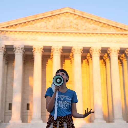 An activist speaking into a megaphone outside the Supreme Court.