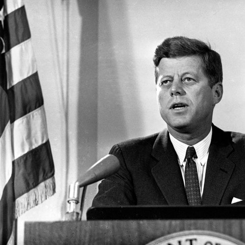 Black-and-white image of U.S. President John F. Kennedy, standing at a podium and reporting to the nation on the status of the Cuban crisis from Washington, D.C.