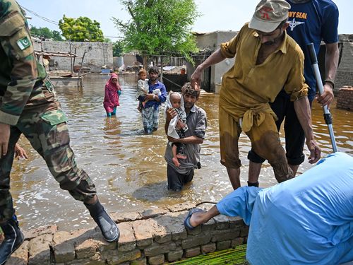 Pakistan’s naval personnel rescue flood-affected people from their damaged houses, after heavy monsoon rains in Dadu District.