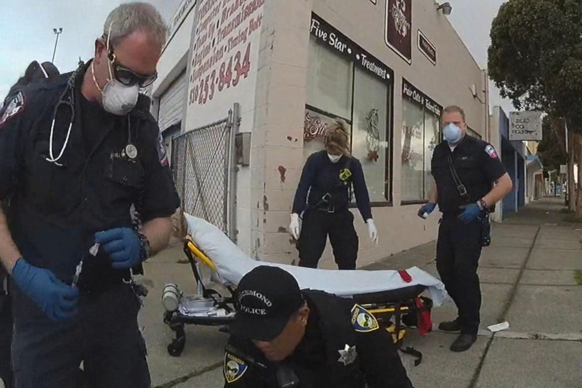 Image from Richmond Police Department body-camera video shows a paramedic, left, holding a syringe as he prepares to inject Ivan Gutzalenko with the sedative midazolam in Richmond, Calif.