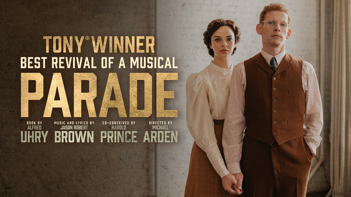 TONY WINNER | BEST REVIVAL OF A MUSICAL | PARADE | A husband and a wife standing close. holding hands as they look at the camera.