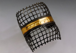 A mesh-style cuff bracelet with a gold center bar