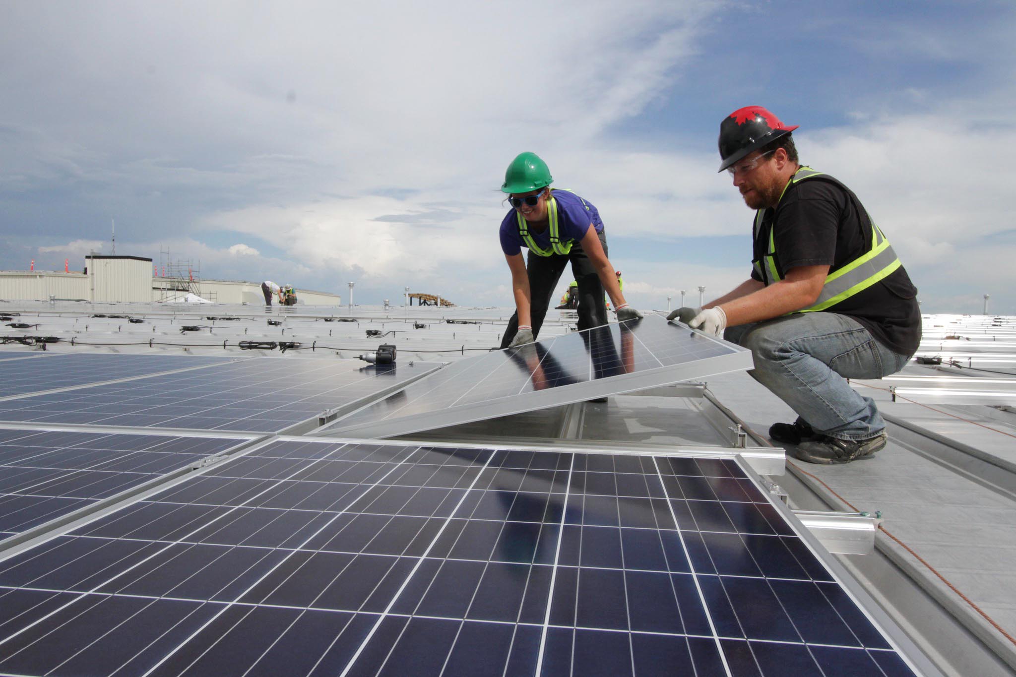 People installing rooftop solar panels